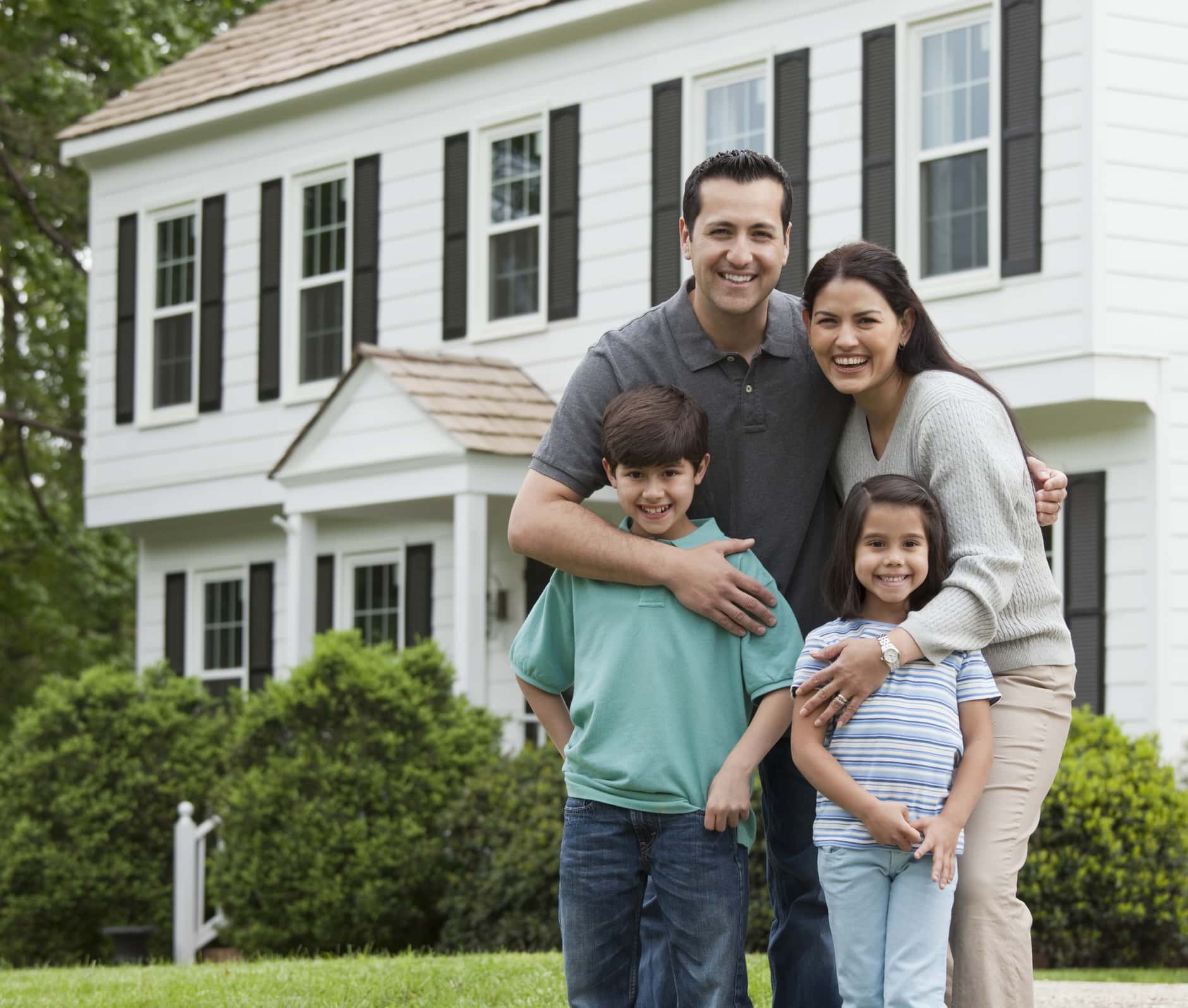 Hispanic family posing in front of house